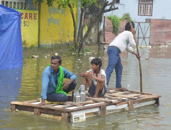 Muzaffarpur: People brave the flood waters as they move to safer places in Bihar’s flood-hit Muzaffarpur district on July 26, 2020. (Photo: IANS)